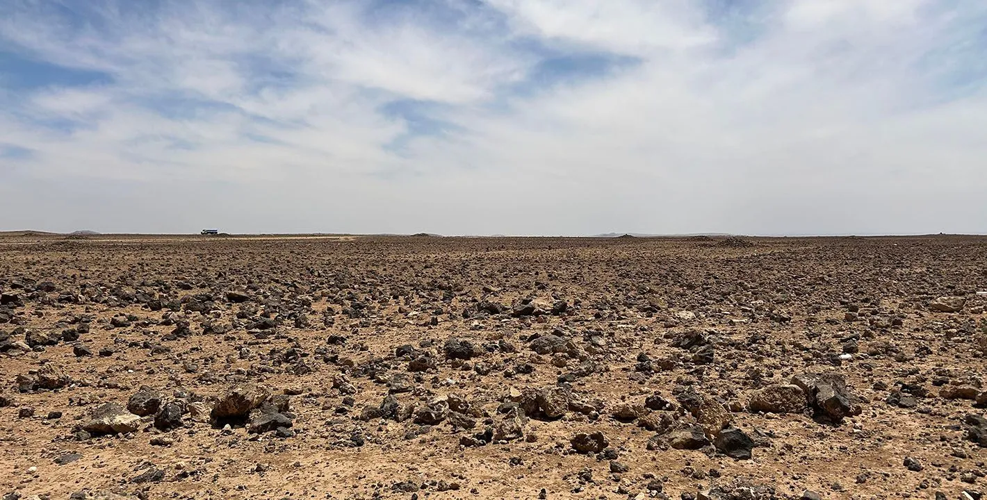 بالقرب من دير الكهف، تنبسط أرضٌ قاحلة، وكأنّ السماء أمطرت يومًا حجارةً بازلتية، لواء البادية الشمالية، محافظة المفرق، الأردن